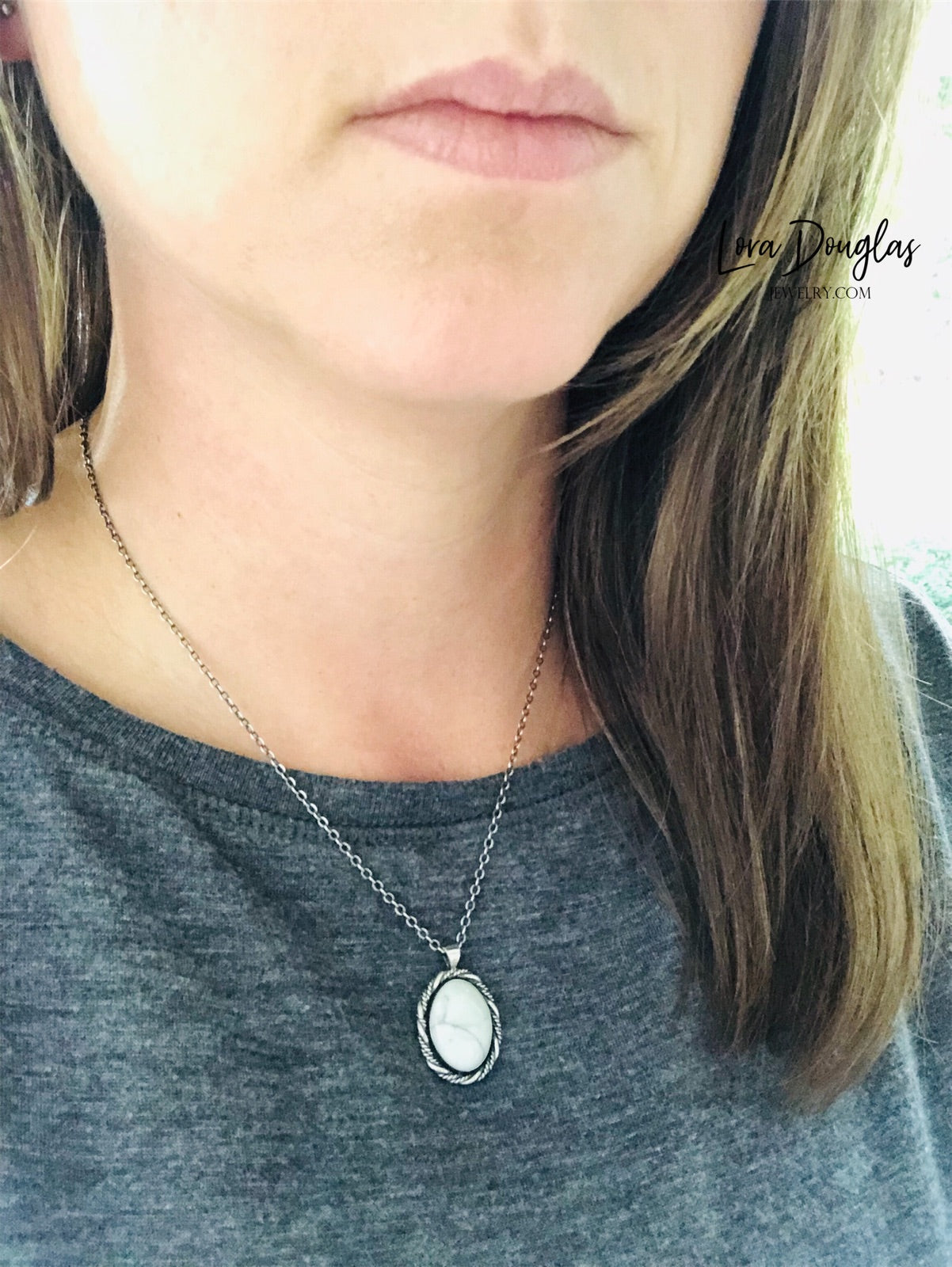 A sterling silver pendant necklace with a white howlite stone set in a silver setting, attached to an 18-inch sterling silver chain with a C clasp.