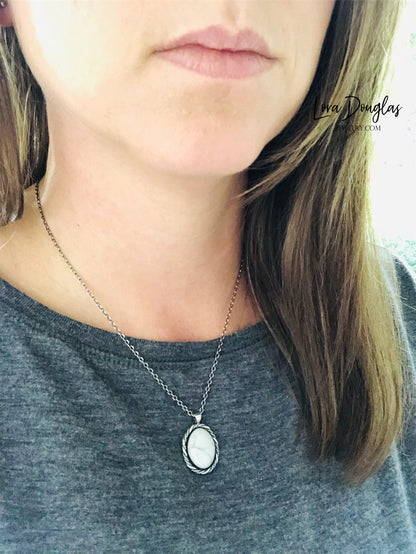 A sterling silver pendant necklace with a white howlite stone set in a silver setting, attached to an 18-inch sterling silver chain with a C clasp.