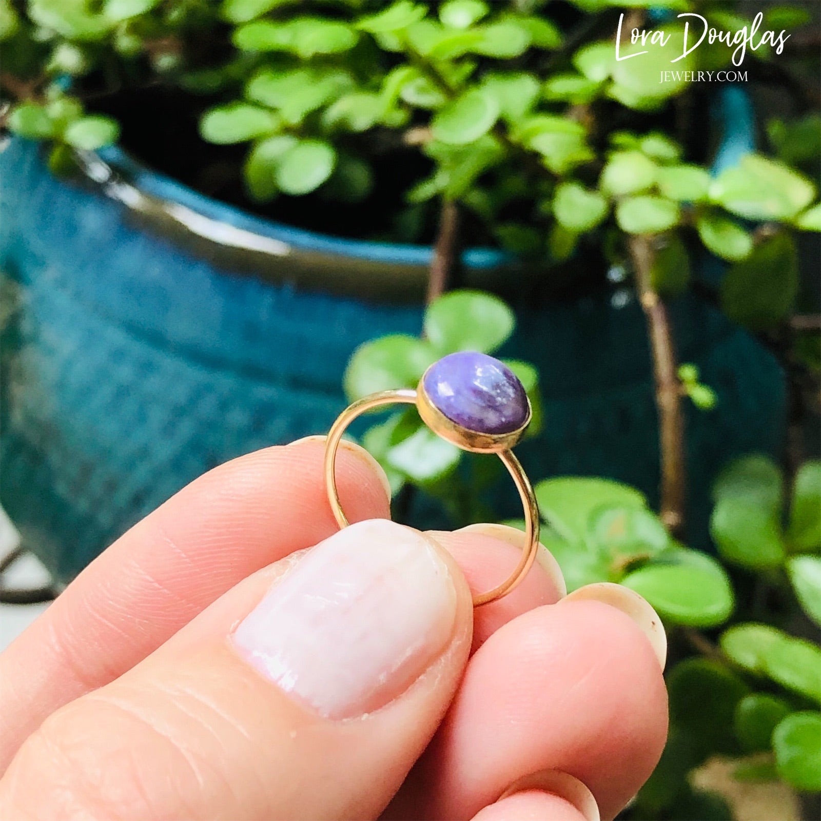 Gold-filled ring with a purple charoite stone set in a gold-filled band, displayed against a white background.