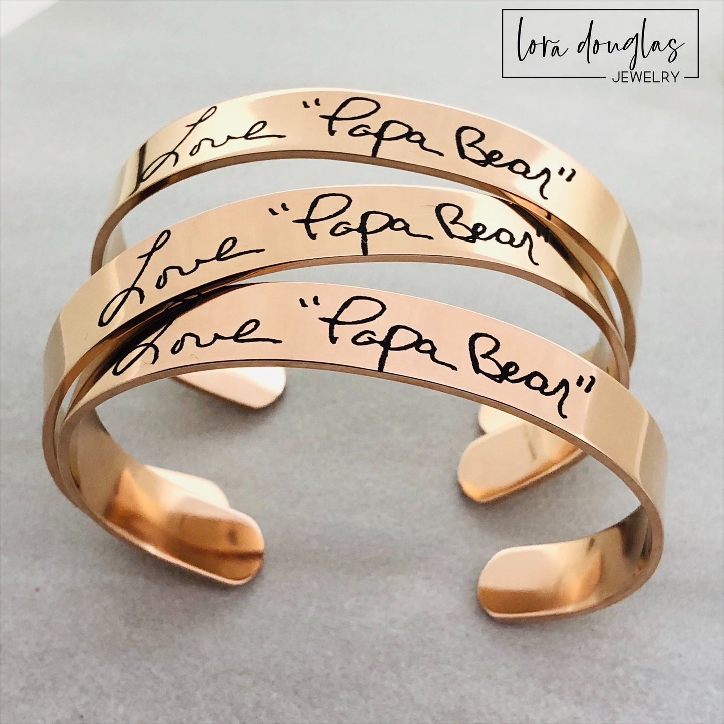 A rose gold stainless steel bracelet engraved with handwriting 