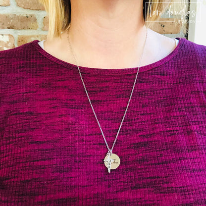 A stainless steel medical alert necklace with a round pendant displaying medical information and a 24-inch chain.