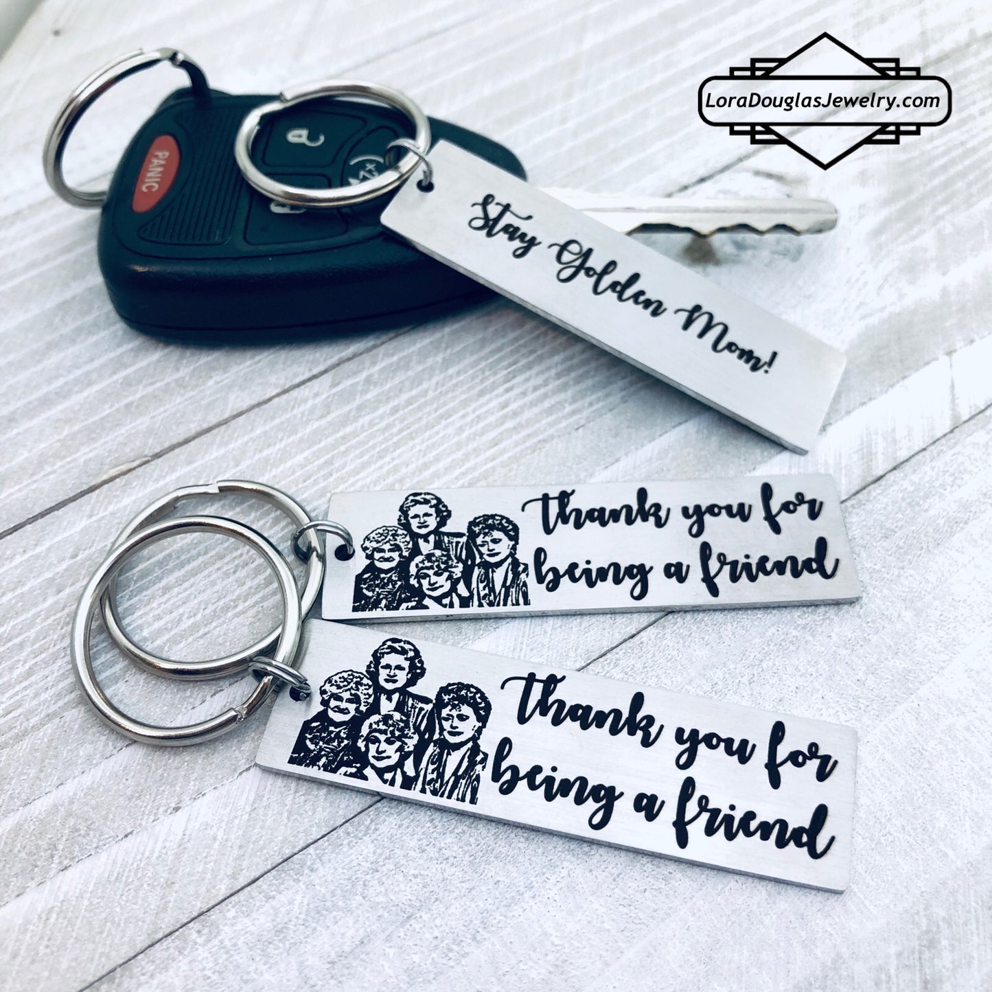A stainless steel key chain with an engraved design of the Golden Girls characters and the text 'Thank you for being a friend'.