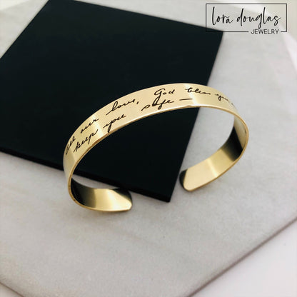 A gold stainless steel bracelet engraved with handwriting 