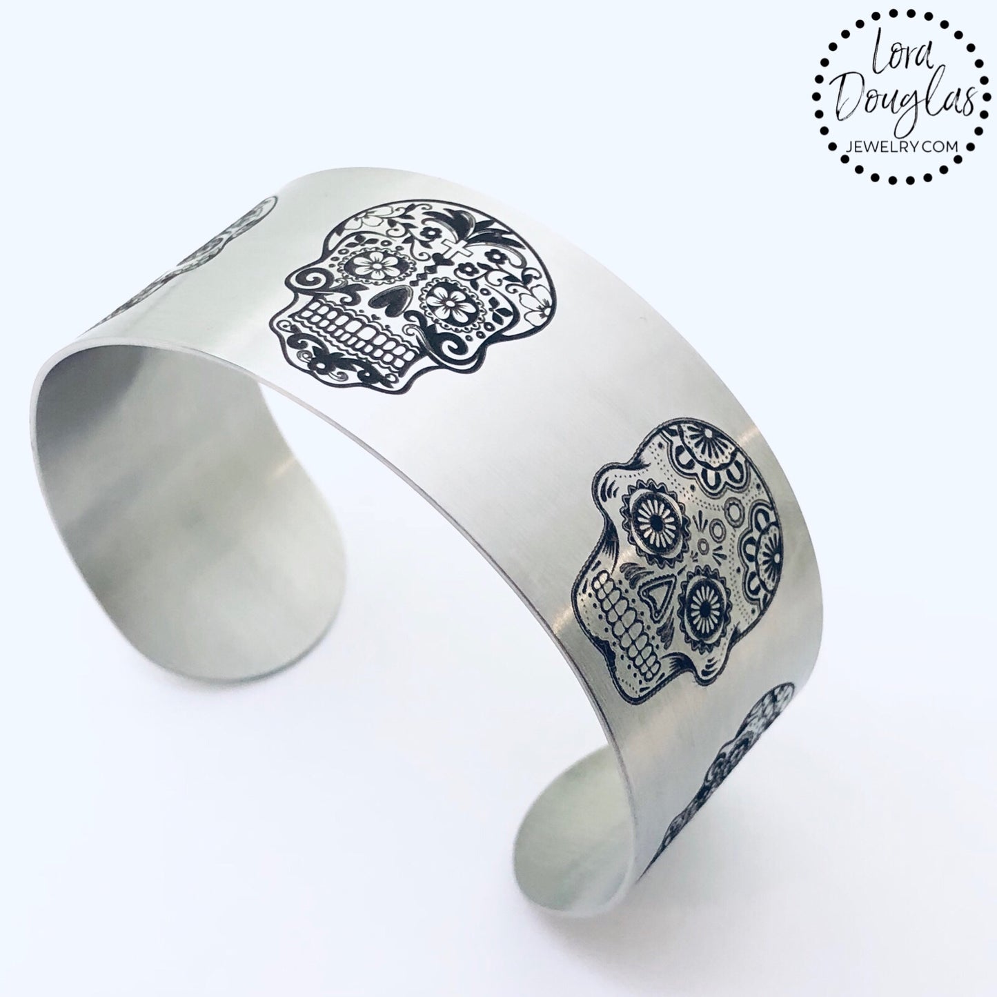 stainless steel cuff bracelet engraved with images of sugar skulls