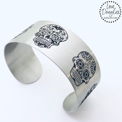 stainless steel cuff bracelet engraved with images of sugar skulls