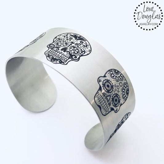 stainless steel cuff bracelet engraved with images of sugar skulls
