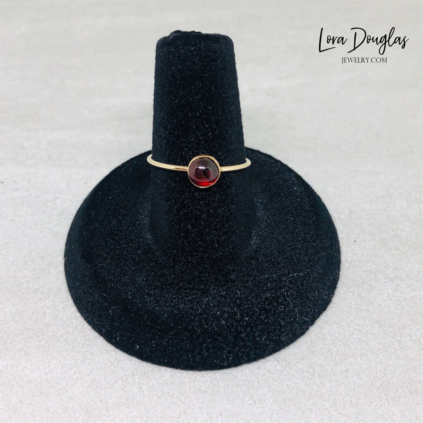 Gold-filled garnet solitaire ring, size 6, with a flat band and a polished finish, displayed on a plain background.