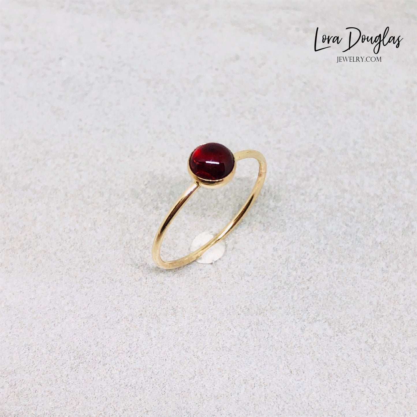 Gold-filled garnet solitaire ring, size 6, with a flat band and a polished finish, displayed on a plain background.