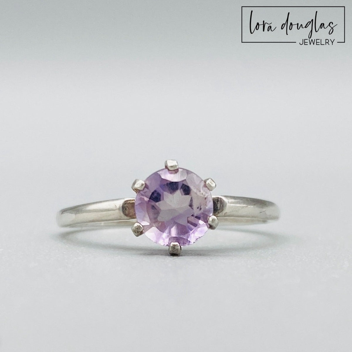 Pink amethyst ring featuring a 6mm lavender pink gemstone set in sterling silver, shown as a finished US size 6.5 solitaire ring for shoppers looking for delicate amethyst and natural gemstone jewelry.
