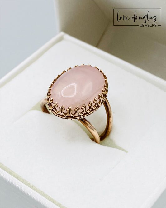 Rose quartz and bronze ring featuring a natural 18mm x 13mm pink gemstone, with the substantial stone as the focal point of this finished size 6 ring for lovers of distinctive gemstone jewelry.

