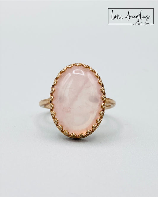 Rose quartz and bronze ring featuring a natural 18mm x 13mm pink gemstone, with the substantial stone as the focal point of this finished size 7.5 ring for lovers of distinctive gemstone jewelry.
