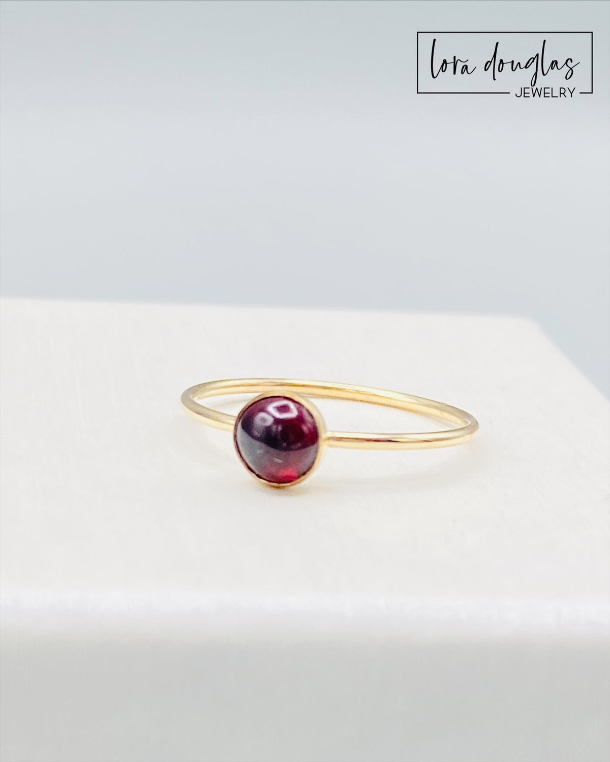 Second anniversary gift ring featuring a rich red garnet in a warm 14/20 gold filled solitaire setting, with a petite 5mm gemstone and finished US size 6 band for a meaningful jewelry gift for her.
