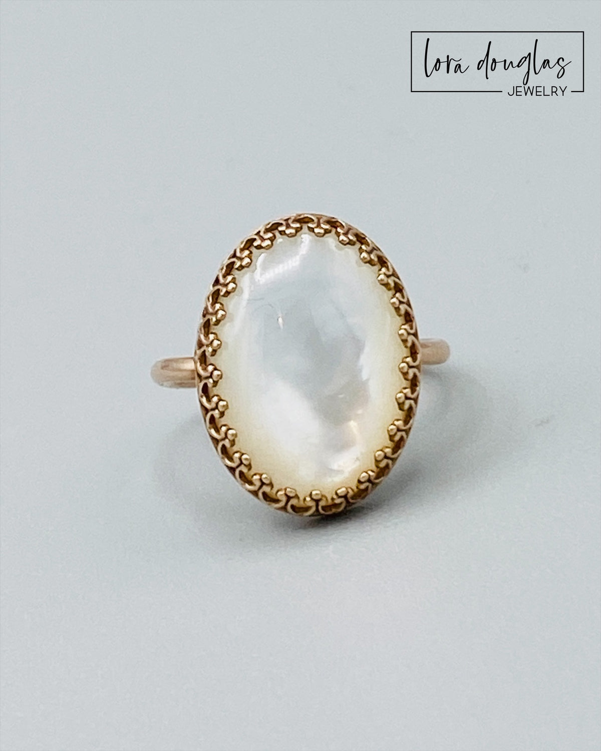 Size 6 Mother of Pearl ring with a natural 18 x 13 mm shell stone and warm bronze setting. The subtle iridescent surface catches the light, creating a distinctive statement ring for natural jewelry lovers.