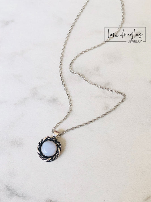 Sterling silver chalcedony pendant necklace featuring a soft colored 8mm gemstone in a petite silver setting, paired with an 18 inch sterling silver chain for an understated natural gemstone jewelry look.

