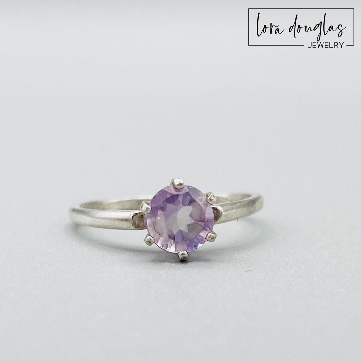 Sterling silver pink amethyst solitaire ring featuring a petite 6mm gemstone with soft lavender and pink tones, shown in finished US size 6.5 for lovers of understated gemstone and birthstone jewelry.
