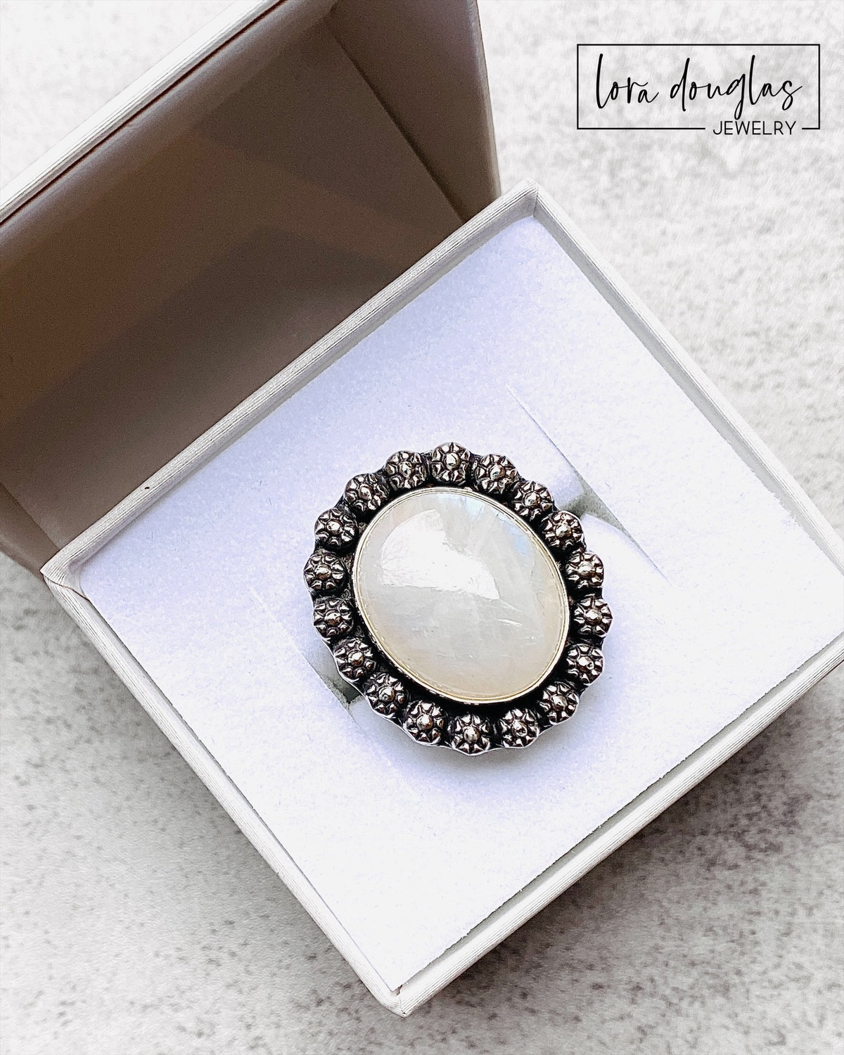 Sterling silver statement ring featuring a large natural moonstone gemstone in a substantial handcrafted setting. This one of a kind size 9 silver ring is a unique gift for women who collect natural stone jewelry.