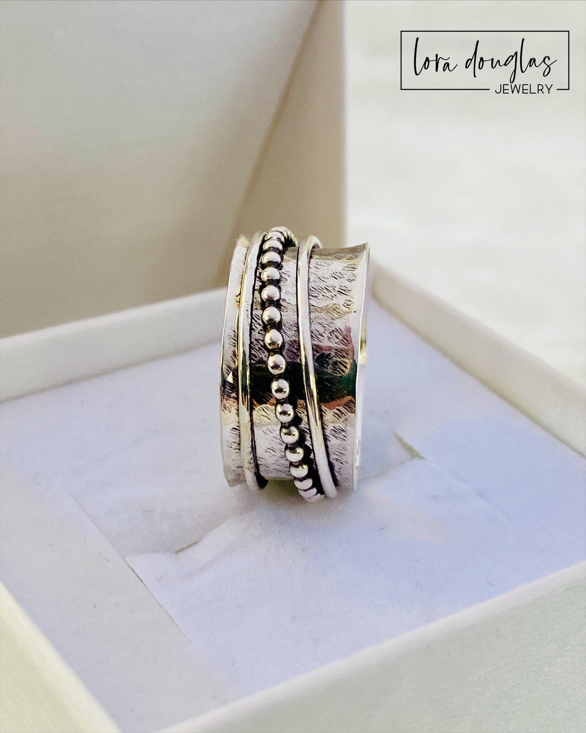Sterling silver worry ring featuring three interactive moving components that spin around the central band, shown in size 8.5 for shoppers looking for a meditation ring, fidget ring or tactile silver jewelry.
