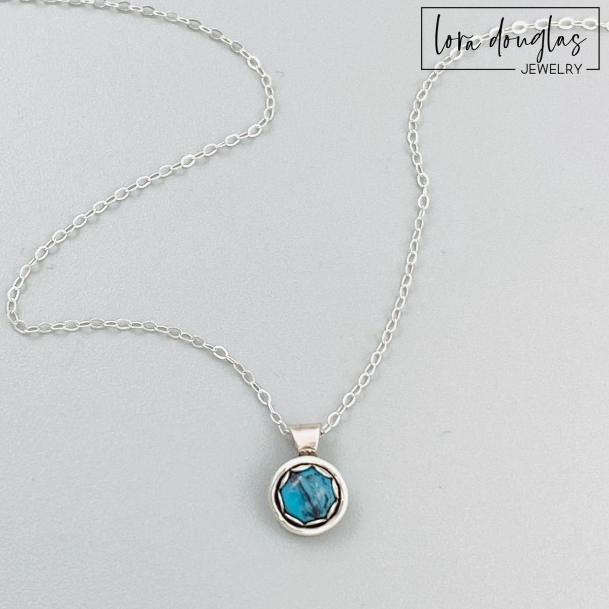 Natural turquoise necklace featuring a petite 5mm blue gemstone in an 11mm x 8mm sterling silver pendant, paired with an 18 inch sterling silver chain with an antique patina and C clasp.
