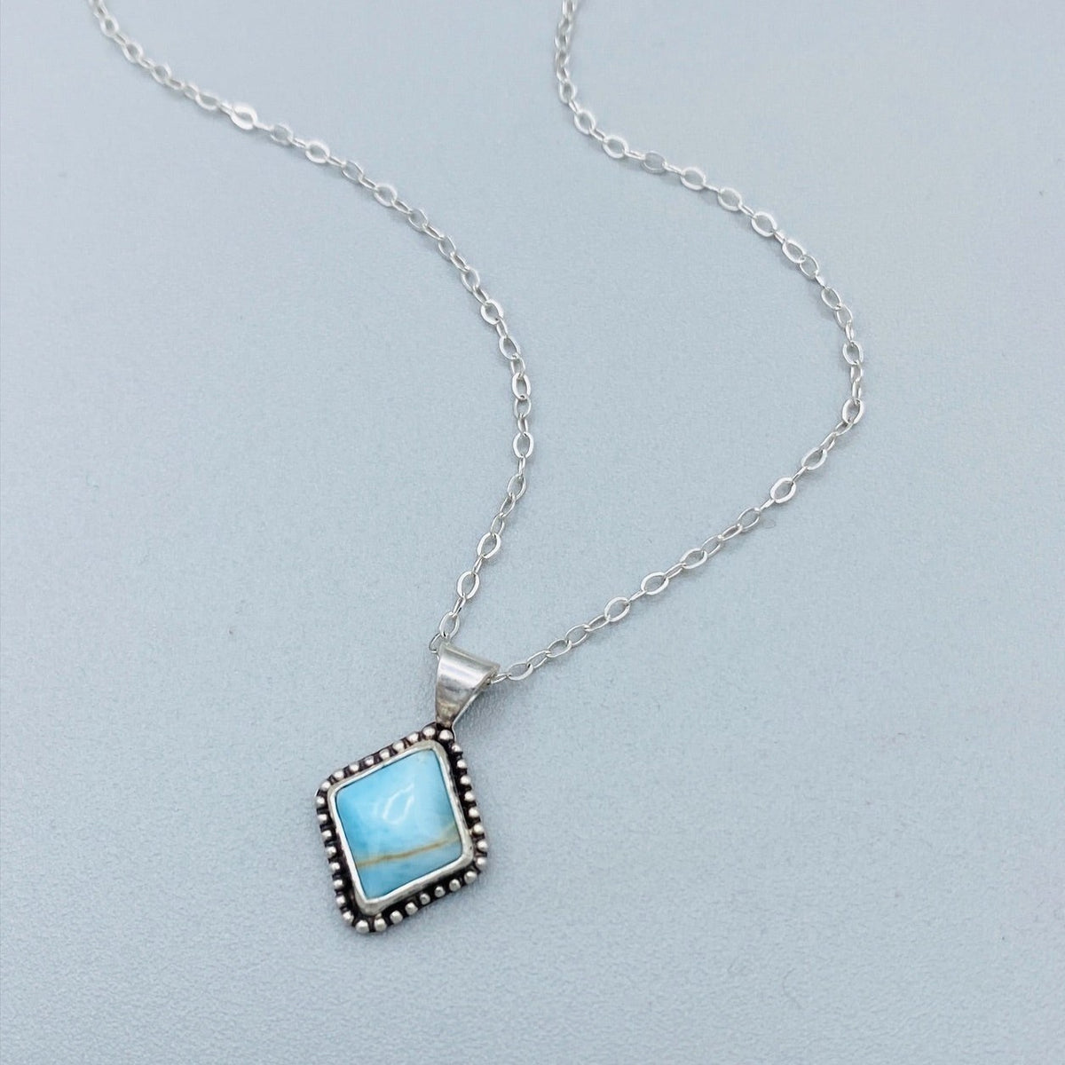 Turquoise sterling silver necklace featuring a natural blue gemstone measuring approximately 10mm x 9mm in a petite silver pendant on an 18 inch chain, a versatile choice for shoppers who love natural stone jewelry.
