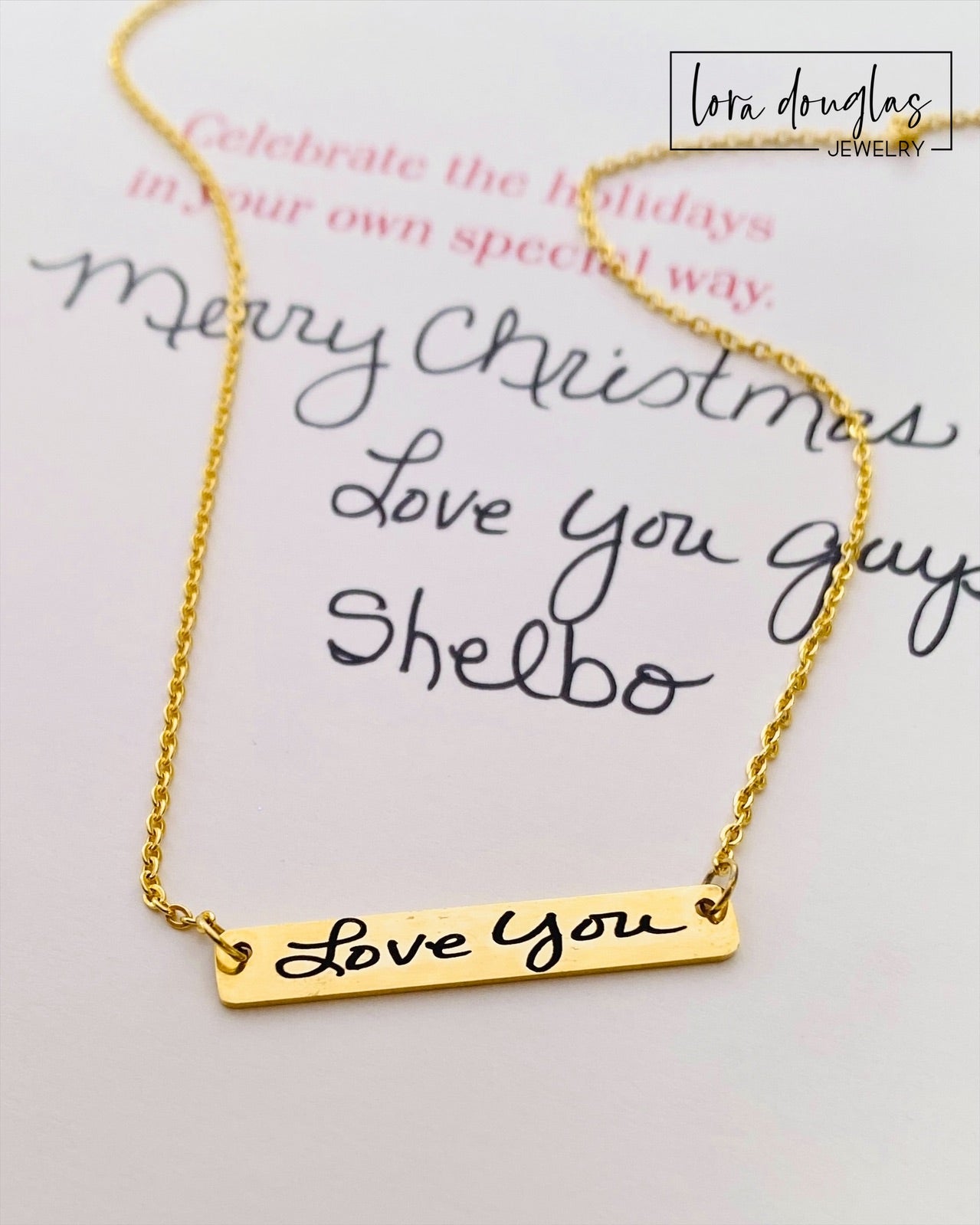 A gold bar necklace with engraved handwriting on it custom signature necklace close up engraving detail stainless steel