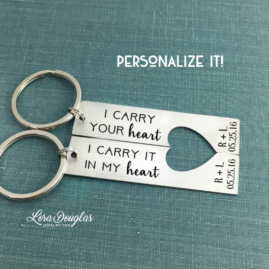 Two stainless steel key chains with laser engraved text 'I CARRY YOUR HEART' and 'I Carry it IN MY HEART' respectively, on a white background.