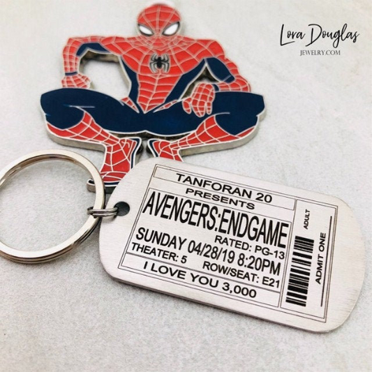A stainless steel key chain featuring an engraved design of a movie ticket personalized with event info.