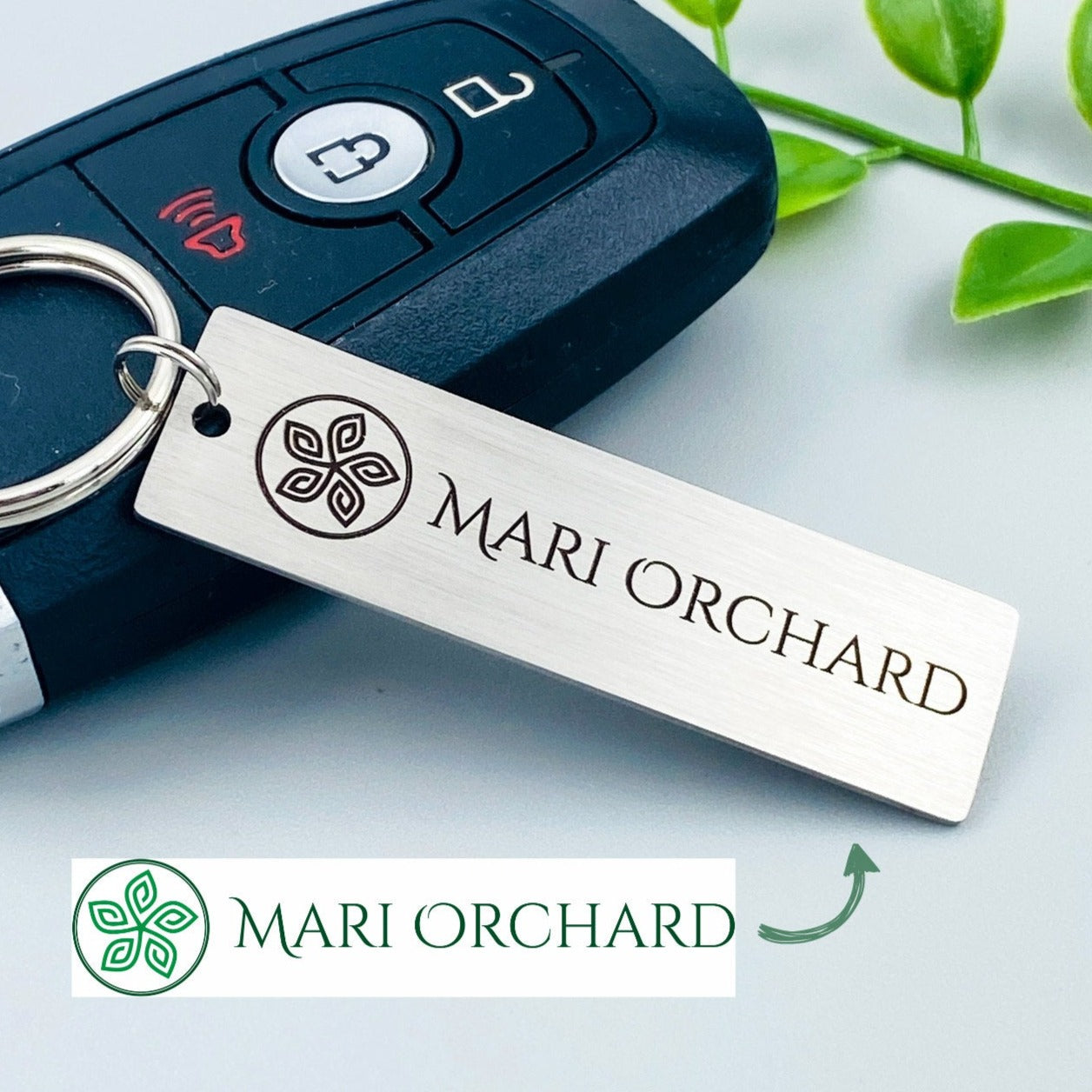 A silver stainless steel keychain with a custom logo engraving