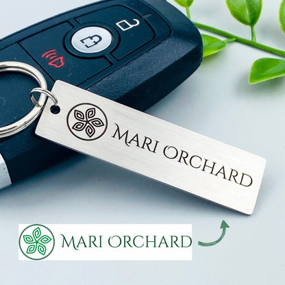 A silver stainless steel keychain with a custom logo engraving