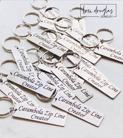A stainless steel keychain with a laser engraved personalized message. The keychain has a rectangular tag with an example of custom text that can be added, indicating it is a personalized product.