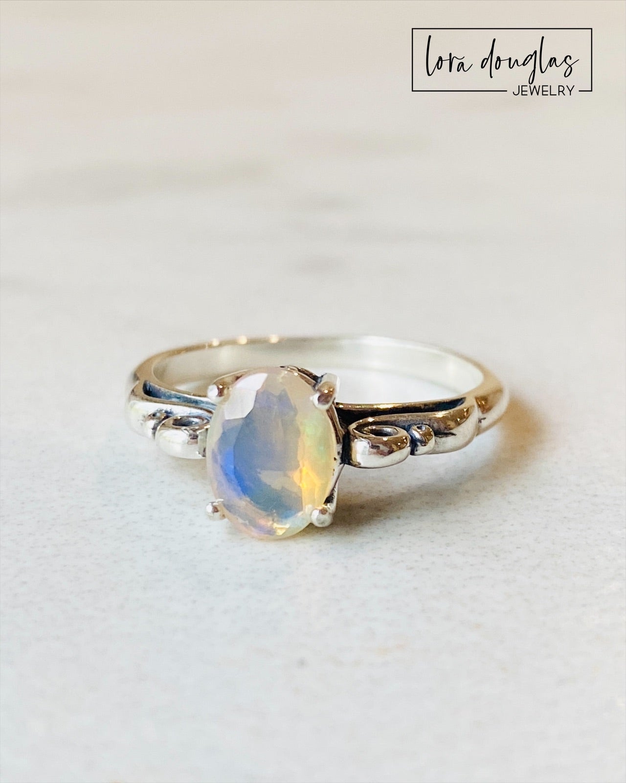 A sterling silver ring with a central opal stone