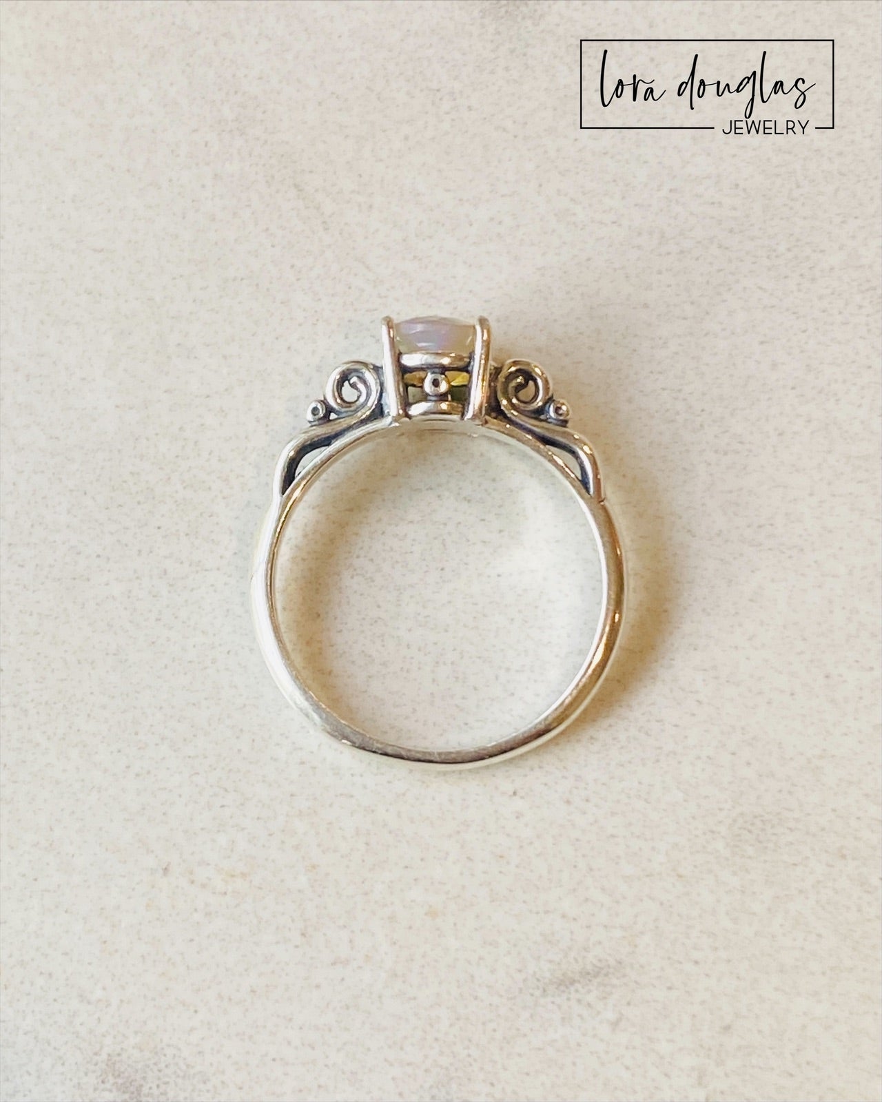 A sterling silver ring with a central opal stone