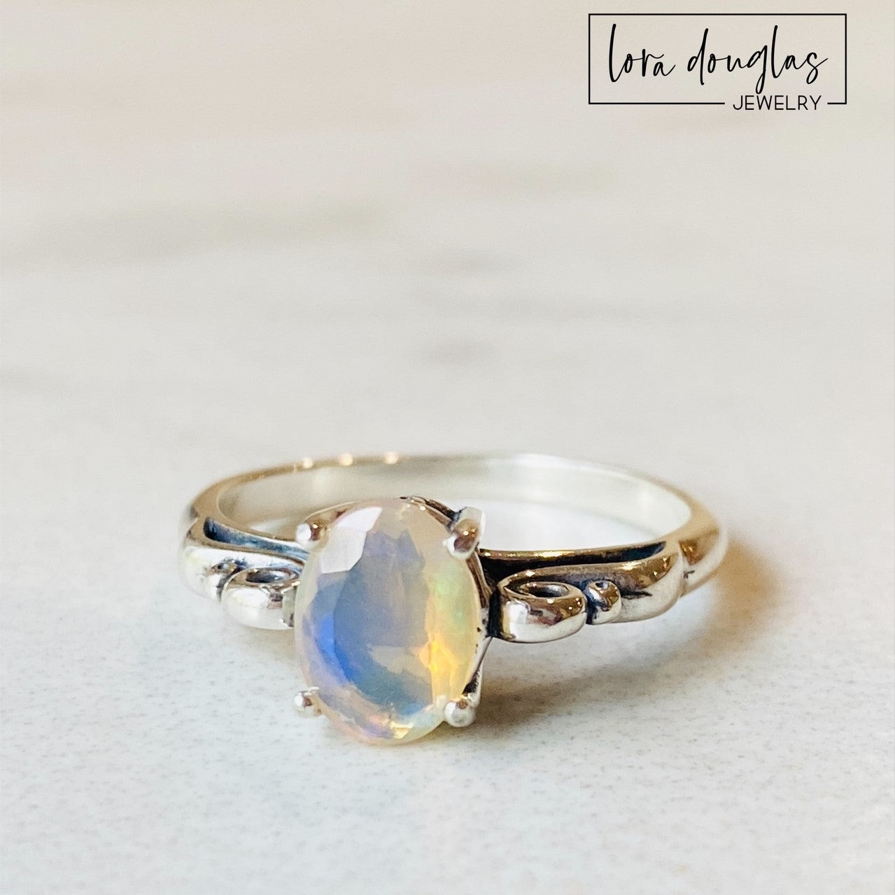 A sterling silver ring with a central opal stone