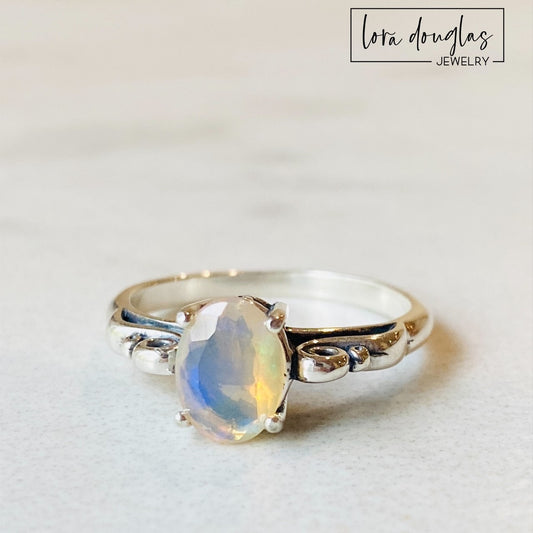 A sterling silver ring with a central opal stone