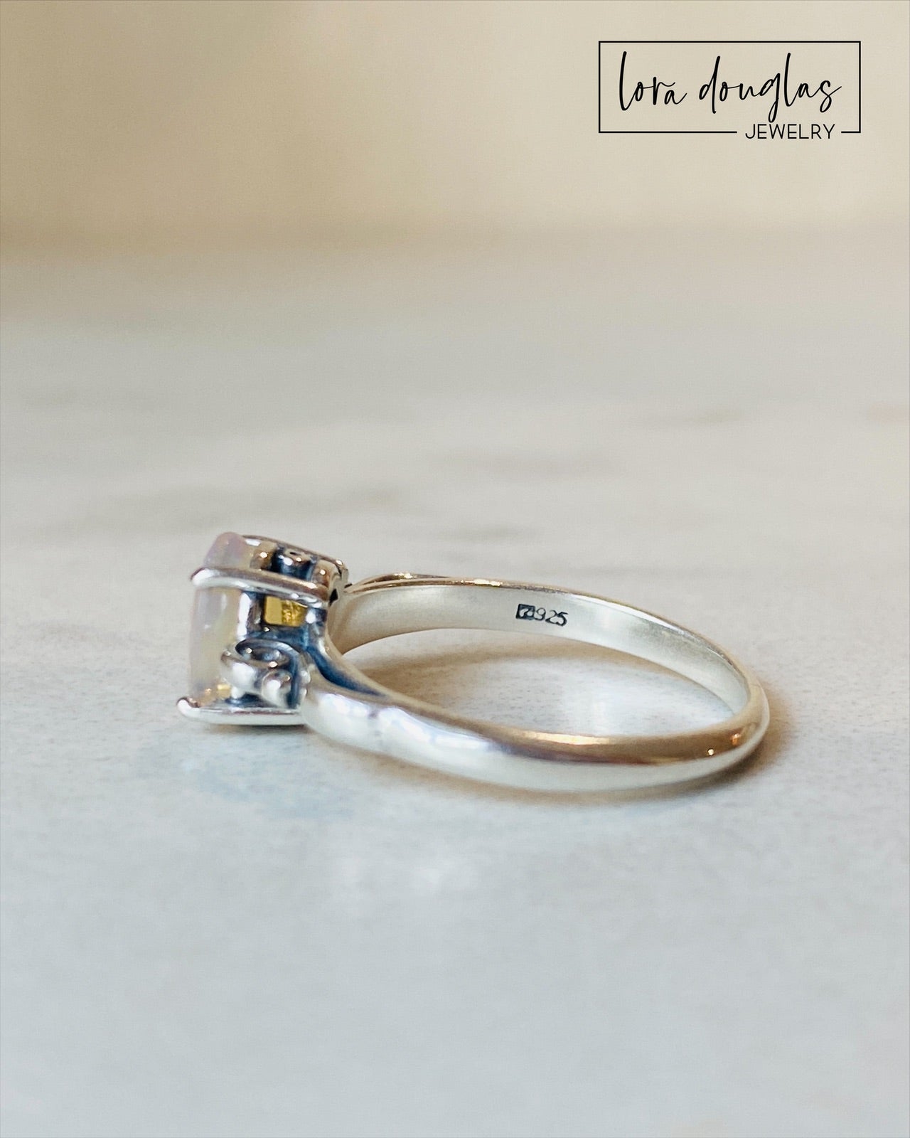 A sterling silver ring with a central opal stone