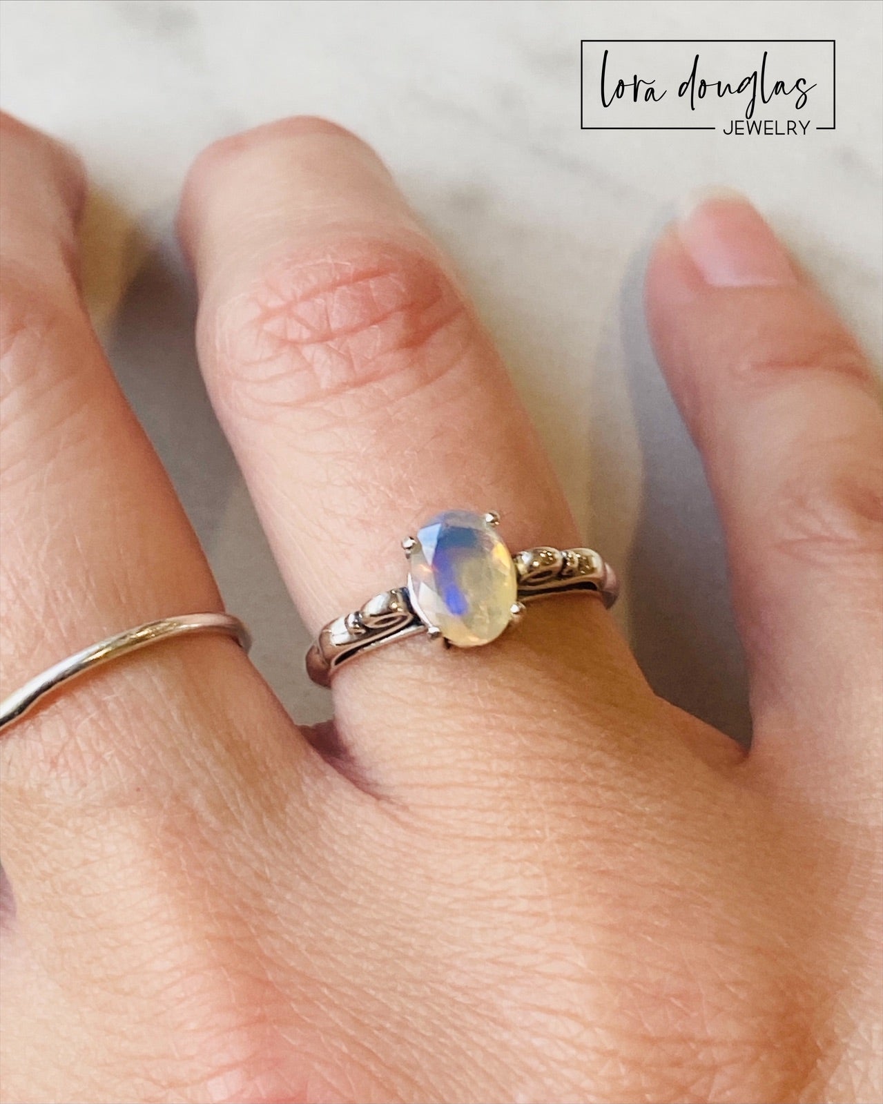 A sterling silver ring with a central opal stone