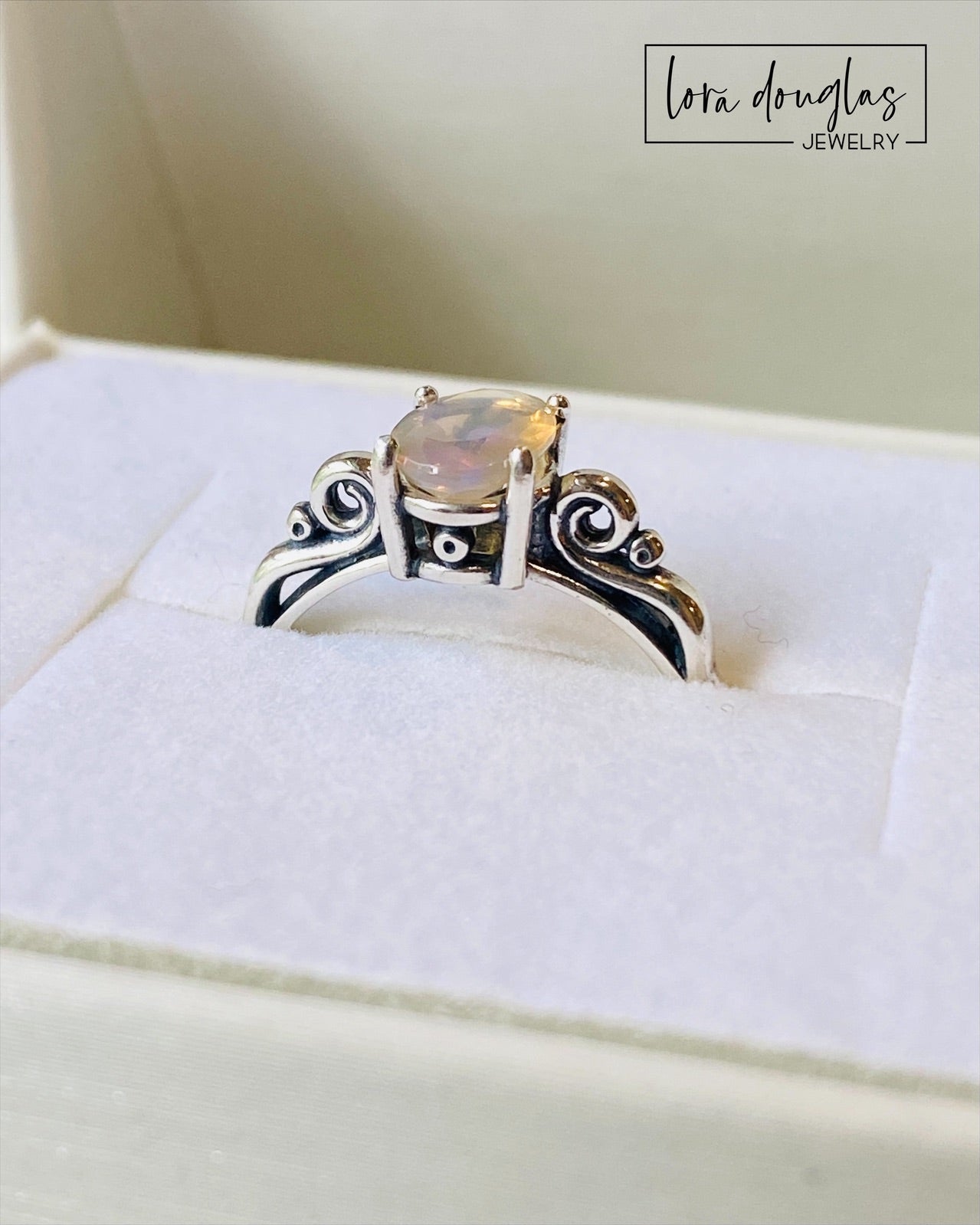 A sterling silver ring with a central opal stone