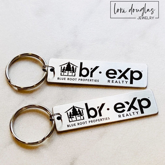 A silver stainless steel keychain with a custom logo engraving