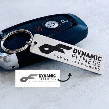 A silver stainless steel keychain with a custom logo engraving, displayed alongside a key fob.