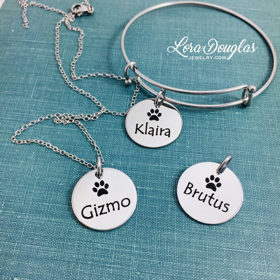 A stainless steel paw print necklace and bangle, with your pet's name engraved on them.