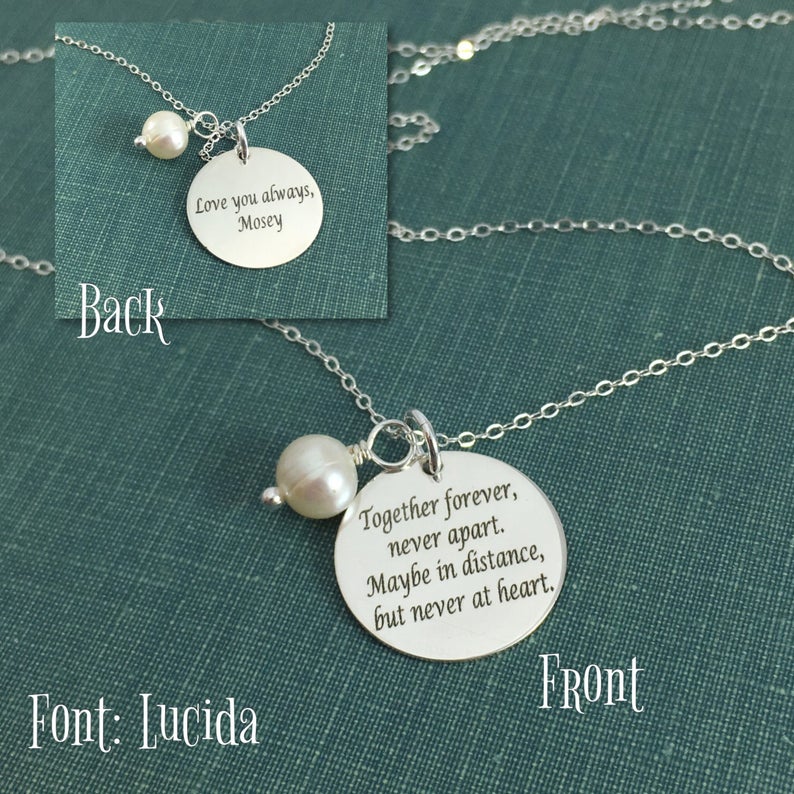 A stainless steel adjustable bangle bracelet with a round pendant that has engraved text 'Together Forever, Never Apart, Maybe in Distance, But Never at Heart'.