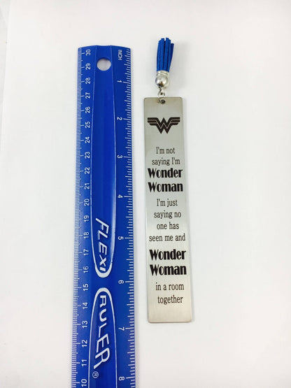 A stainless steel bookmarks with the phrases 'Teach Love Inspire' and 'Thank you for being my teacher' engraved on them, presented in a navy blue velvet pouch with tassels.