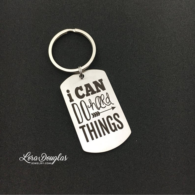 stainless steel keychains with the engraved text 'I CAN DO HARD THINGS' on a black background.