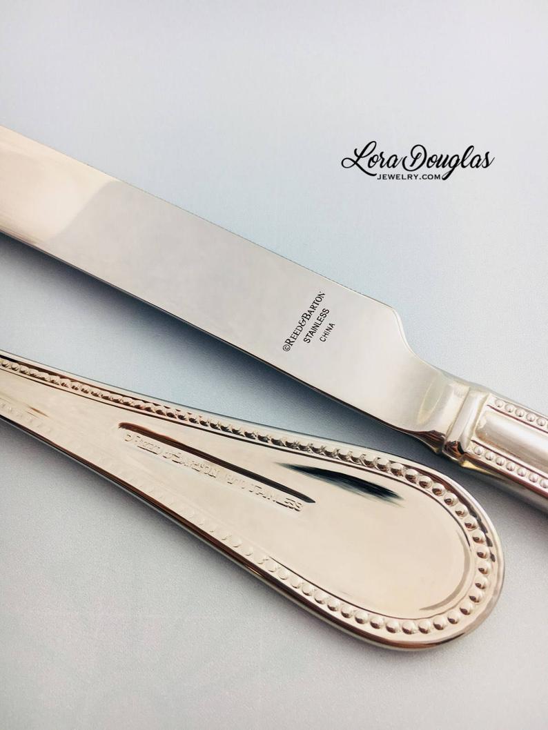 A stainless steel cake knife and server personalized with laser engraved initials and names for wedding cake cutting ceremony 