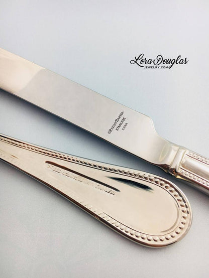 A stainless steel cake knife and server personalized with laser engraved initials and names for wedding cake cutting ceremony 