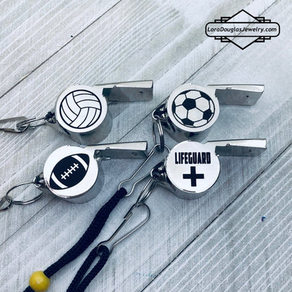 personalized stainless steel whistles with engraved text, one with 'COACH CARLOS' and sports icons, the other with 'FOOTBALL BASKETBALL SOCCER LIFEGUARD AND MORE'. Both whistles have a lanyard 