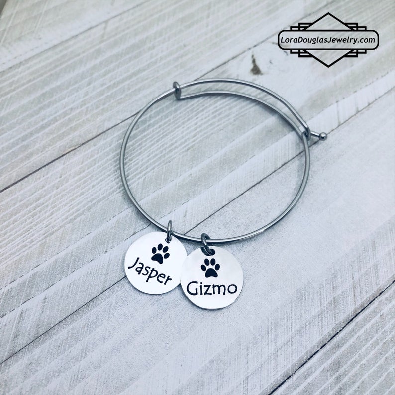 A stainless steel paw print necklace and bangle, with your pet's name engraved on them.