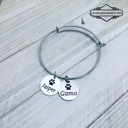 A stainless steel paw print necklace and bangle, with your pet's name engraved on them.