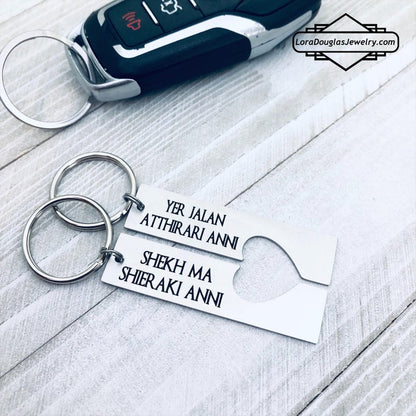 Two silver stainless steel keychains with Dothraki engraving, presented on a car key. One keychain reads 'Yer Jalan Atthirari Anni' and the other reads 'Shekh Ma Shieraki Anni', with optional personalization. Game of Thrones Gift