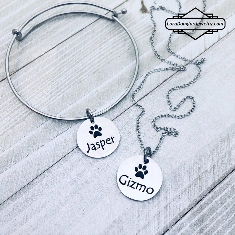 A stainless steel paw print necklace and bangle, with your pet's name engraved on them.