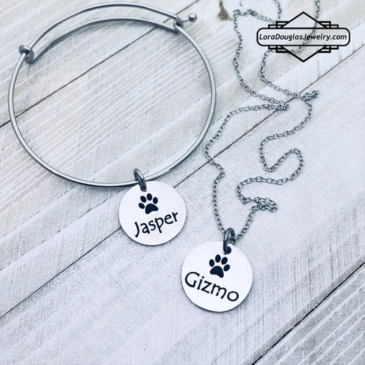 A stainless steel paw print necklace and bangle, with your pet's name engraved on them.